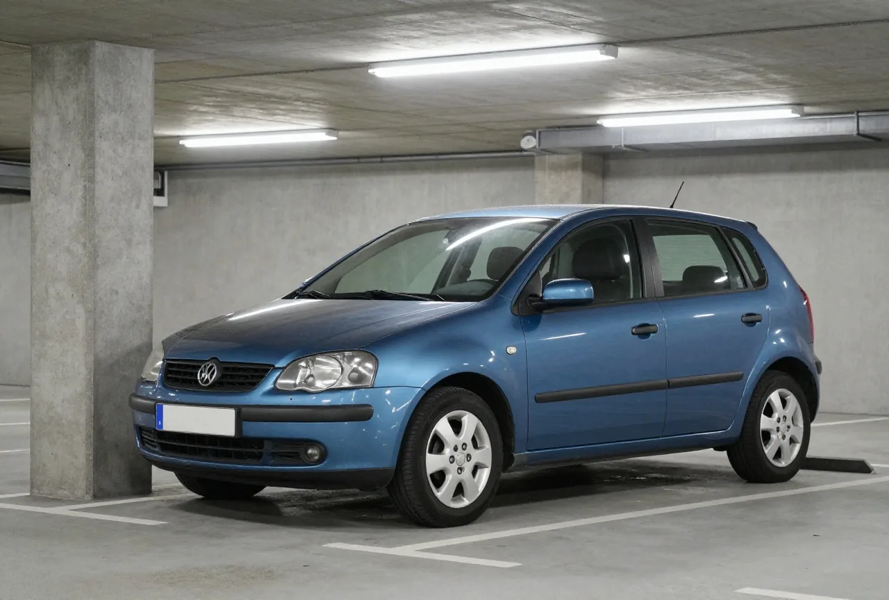 Ein Kleinwagen mit eingedrückter Frontstoßstange steht neben einem niedrigen Betonpfosten in einem Parkhaus